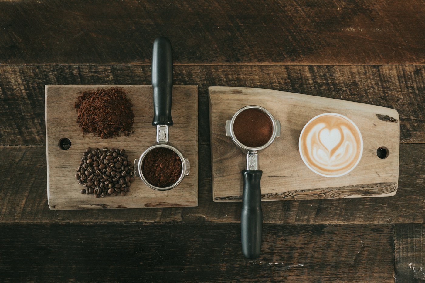 Filterdragers met gemalen koffie, bonen en een latte op houten planken